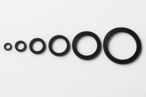 EPDM grooved gaskets in multiple sizes, arranged from smallest to largest on white background, showing dimensional range for industrial pipe couplings.