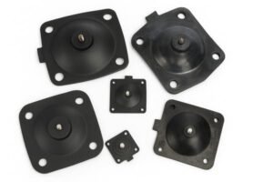 Rubber diaphragms, various sizes with metal center inserts, laid flat on white background, used in pumps, valves, and actuators.