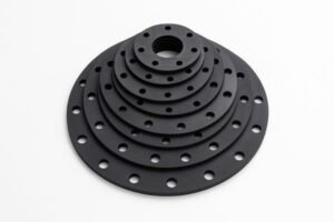 Rubber flange gaskets, stacked by size for display, black flat ring design with bolt holes, used in industrial pipe sealing.
