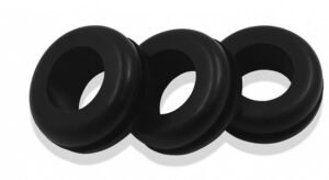 Rubber grommet, black, installed in electrical panels, provides cable protection, prevents wire abrasion, ideal for industrial equipment.