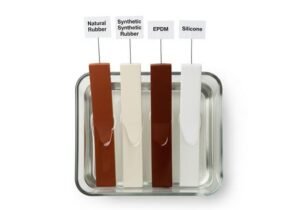 Rubber oil resistance test, strips of natural rubber, synthetic rubber, EPDM, and silicone immersed in coconut oil, showing swelling differences.