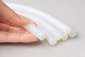 Silicone rubber cords, translucent food-grade silicone tubing held by hand, ideal for medical and food processing applications, flexible and non-toxic.