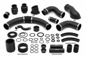 AEM rubber automotive hoses and seals, various black AEM molded parts and vibration dampers, arranged for industrial application.