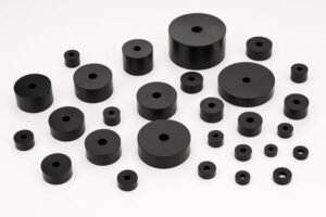 Assorted rubber bumpers in cylindrical shapes with center holes, durable shock-absorbing mounts for vibration damping and industrial machinery protection.