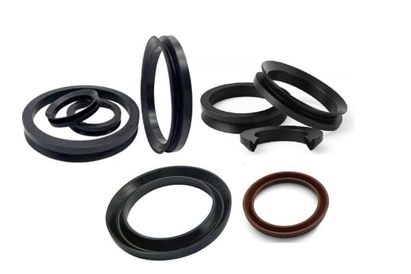 Assorted rubber V-ring seals in black and brown, displayed on a white background, showing various sizes and lip profiles for rotating shaft sealing and dust exclusion.