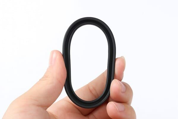Hand holding flexible rubber piston lip seal, oval-shaped sealing ring for hydraulic and pneumatic applications, durable elastomer material