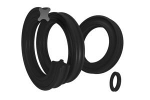 Exploded view of black quad ring seal with visible X-shaped cross-section, showing multiple sealing lips for enhanced leak prevention in hydraulic or pneumatic applications.