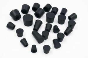 Black rubber stoppers in mixed sizes, conical plugs for laboratory glassware sealing, machinery protection, and leak prevention.