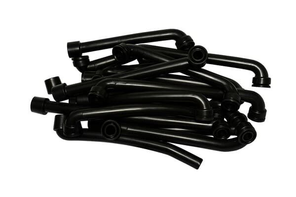 Pile of black molded rubber elbow hoses, surface clean and glossy without blooming, displayed on plain background as quality finished products.