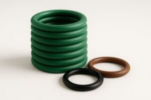 Stack of green HNBR O-rings with additional brown Viton and black NBR seals, showing color variations for industrial sealing applications.