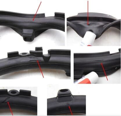 Close up views of black rubber door gasket showing surface defects and damage marked by red arrows