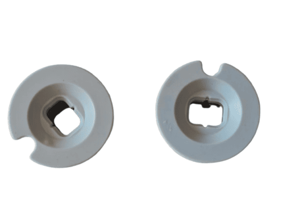 Top view of two white molded rubber caps with central square hole and side notch