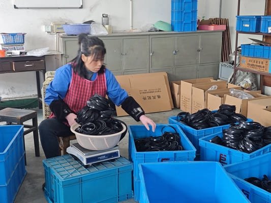 Worker weighing custom black rubber gaskets in Julong Rubber workshop