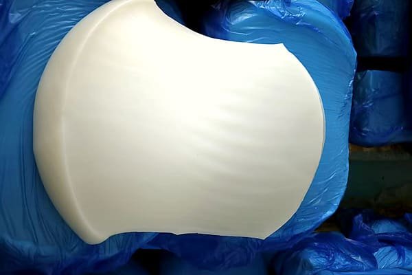 Silicone rubber sheet, large white raw material slab on blue bag liner, prepared for storage and further processing.