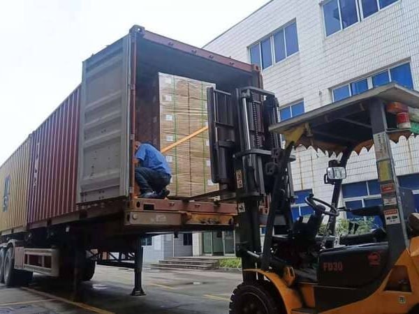 Forklift loading palletized cartons of custom rubber parts into shipping container