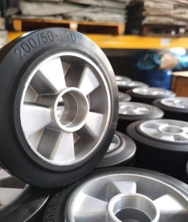 Rubber wheels with aluminum cores, 200/50-140 size, stacked in factory storage, designed for industrial carts and heavy-duty mobility.